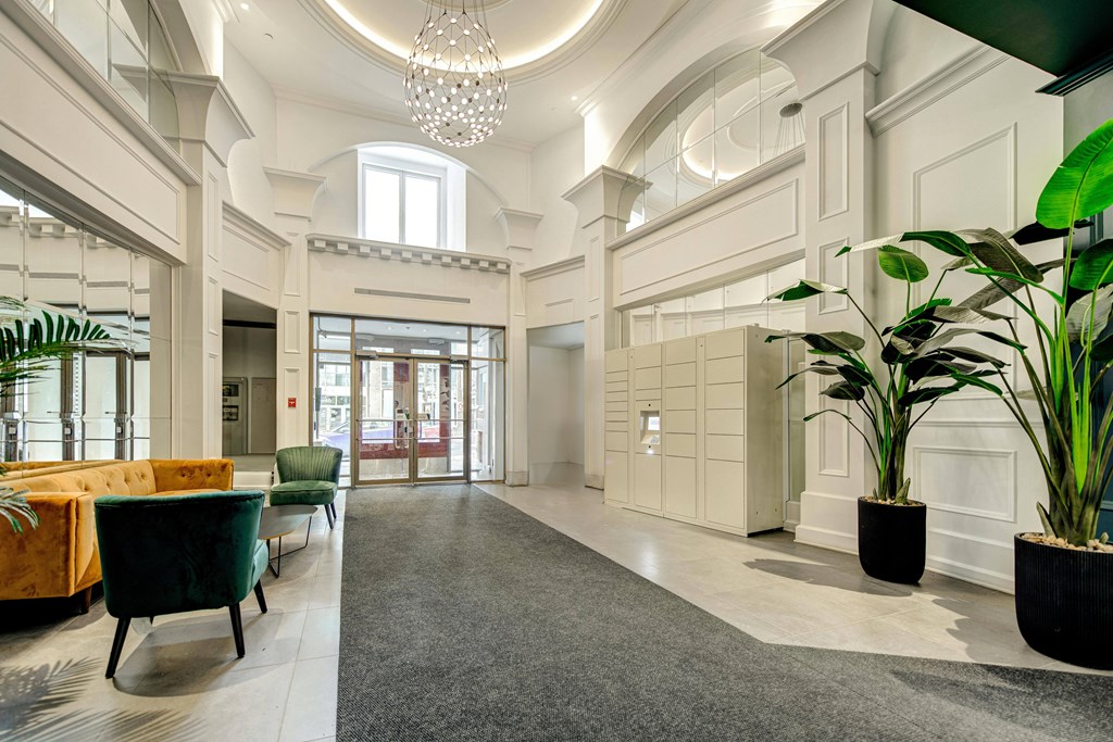 a large lobby with chairs and a table and a chandelier
