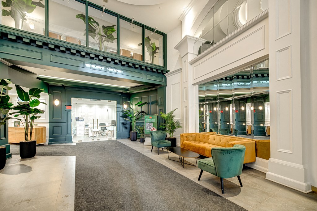 a lobby of a building with a yellow couch and chairs