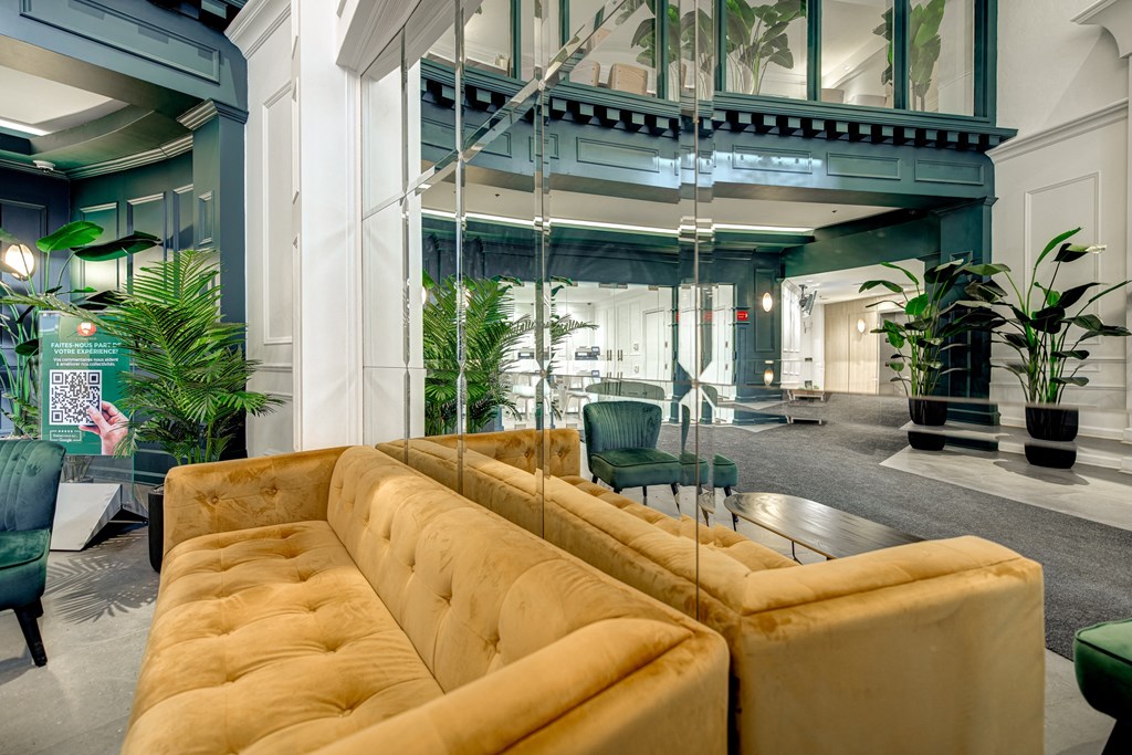 the lobby of a building with a couch and chairs