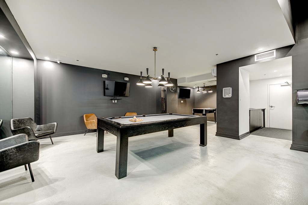 a game room with a pool table and a tv