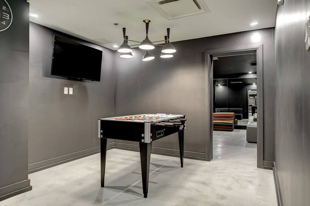 a game room with a foosball table and a tv