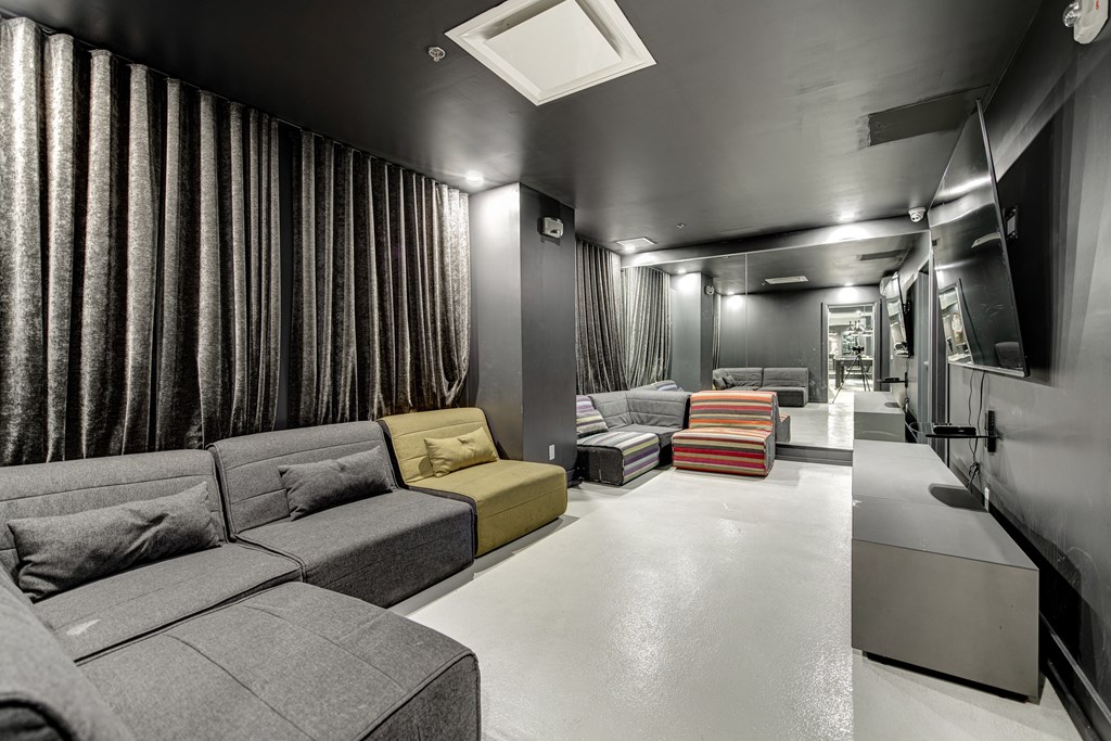 a living room with couches and chairs and a hallway with a staircase