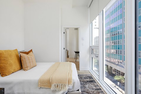 A bedroom with a bed, pillows, and a blanket.