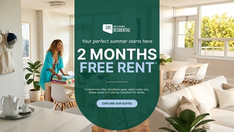 A woman is standing in a bright room with a sign offering 2 months free rent.