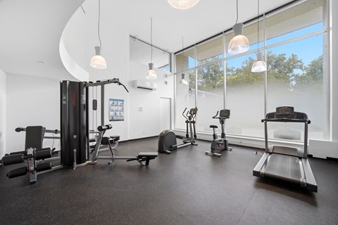 A gym with a variety of equipment including treadmills, weights, and exercise machines.