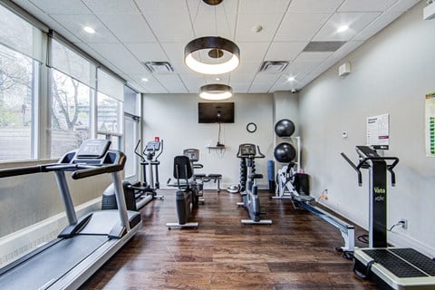 A gym with treadmills, exercise bikes, and weights.