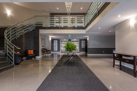 a large lobby with a spiral staircase and a plant in the center