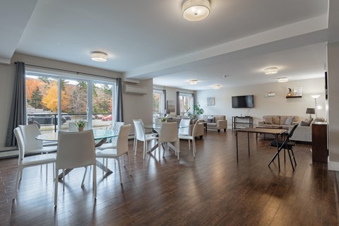 a living room with a table and chairs and a large window