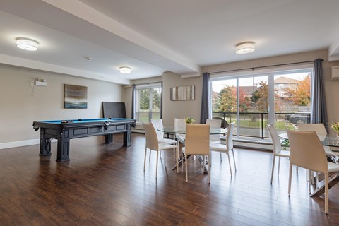 a game room with a pool table and a dining table and chairs