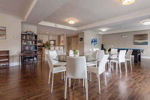 a dining room with a glass table and chairs and a pool table