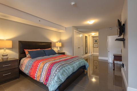 a bedroom with a bed and a hallway with a door to a bathroom