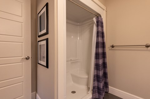 a small bathroom with a shower and a toilet and a towel rack
