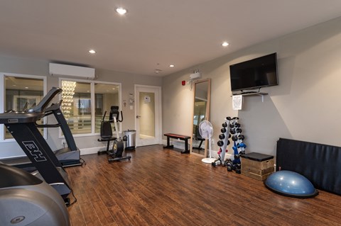 a gym with exercise equipment and a tv on the wall