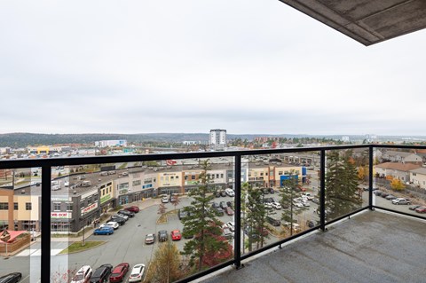 a balcony with a view of a city and a glass railing