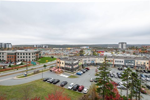 an aerial view of a city with cars parked in a parking lot