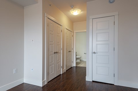 an empty room with two doors and a toilet
