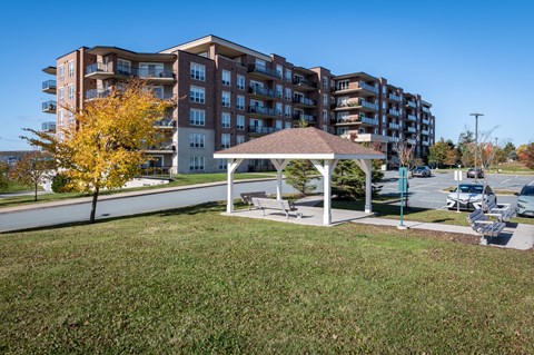a park with a gazebo in front of an apartment building