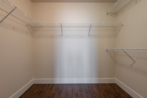 an empty room with white walls and shelves and a wooden floor