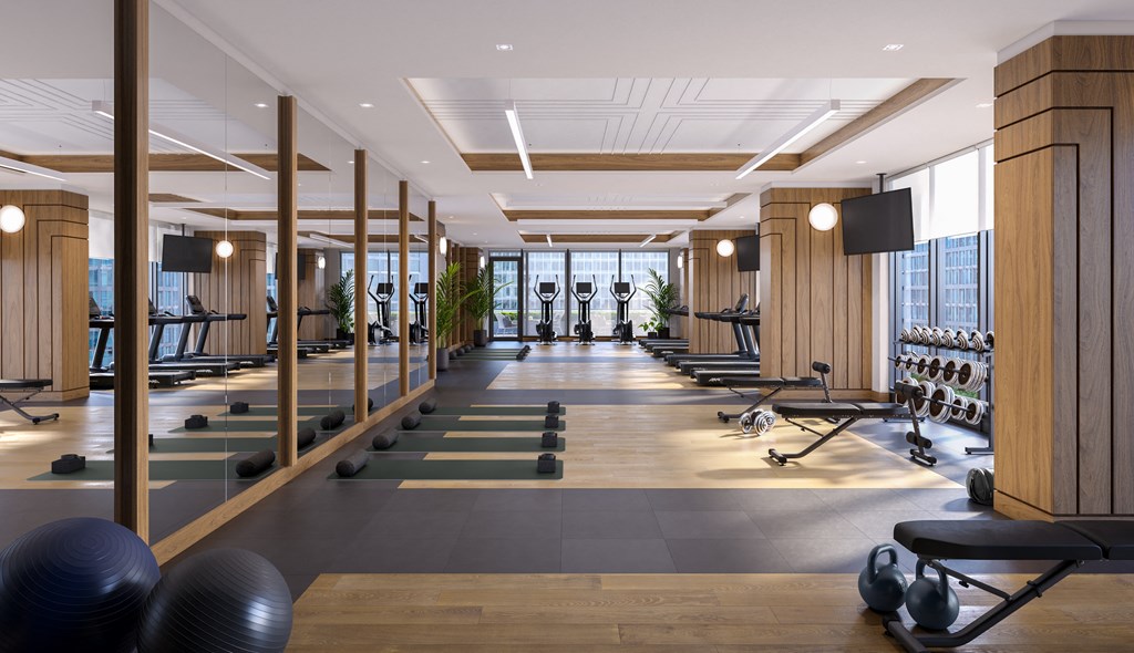 A gym with a row of exercise balls and a row of exercise bikes.