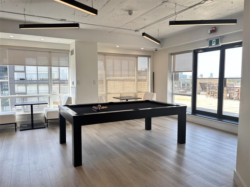 A pool table in a room with a view of the outside.