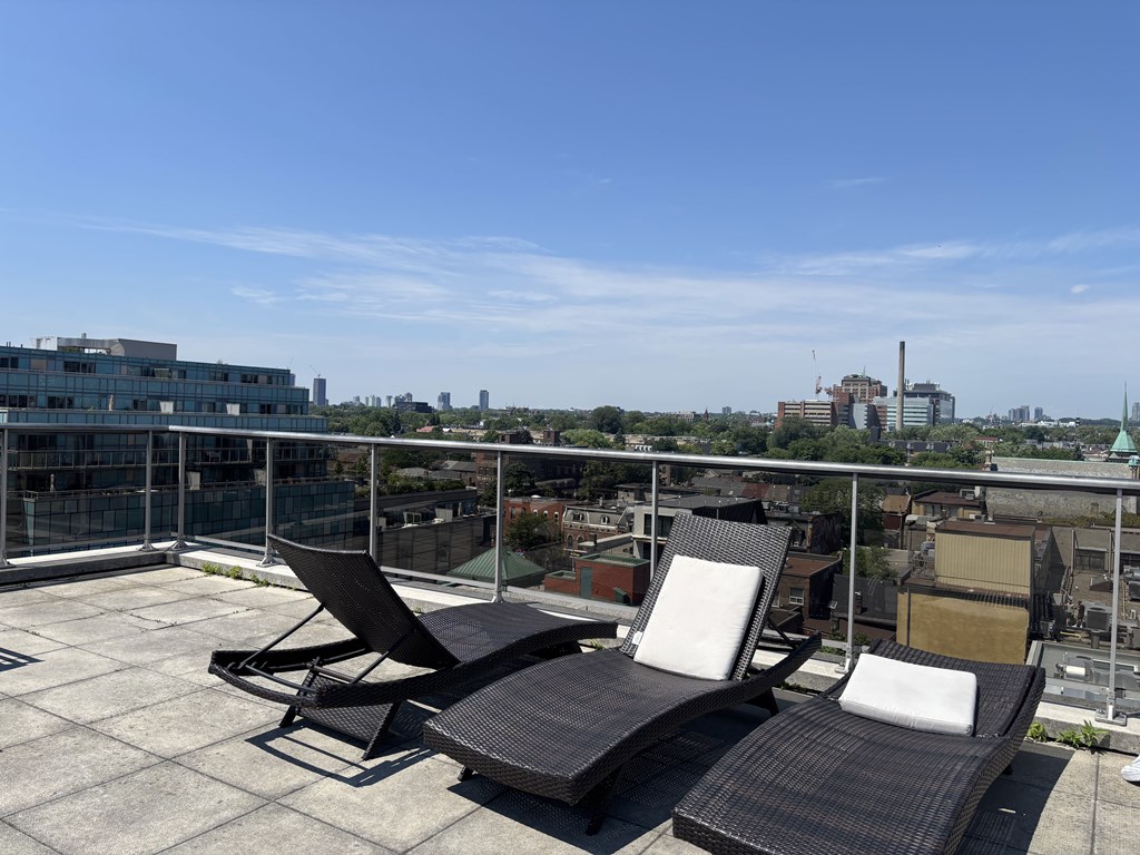 Three lounge chairs are on a rooftop terrace.