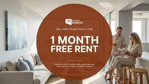 A man and woman are sitting on a couch in a living room, with a large orange circle in the foreground advertising a 1 month free rent offer.
