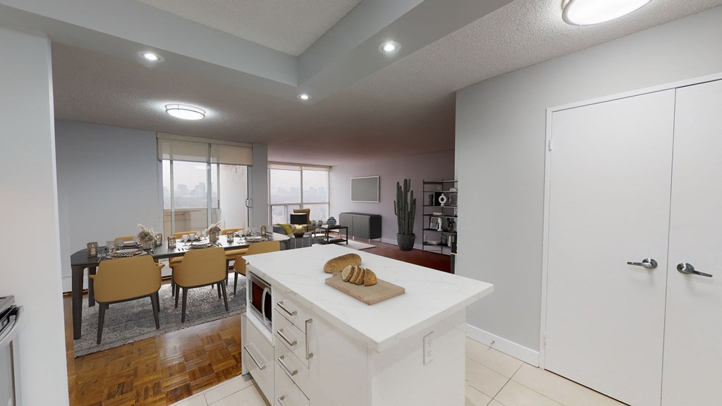 a kitchen with a white island and a dining room with a table and chairs