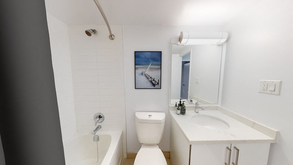 a bathroom with a toilet sink and tub and a mirror