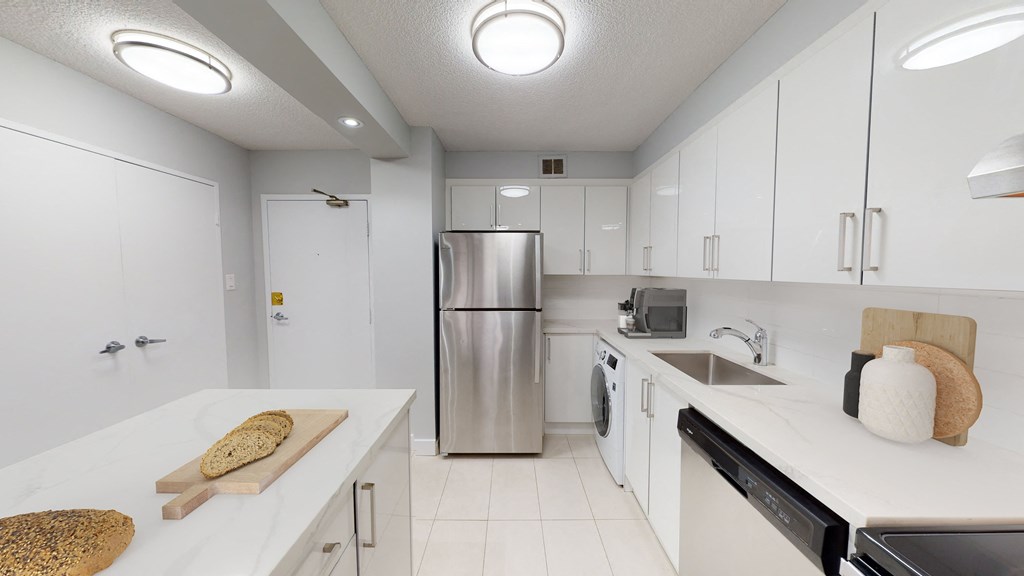 a kitchen with white cabinets and a stainless steel refrigerator