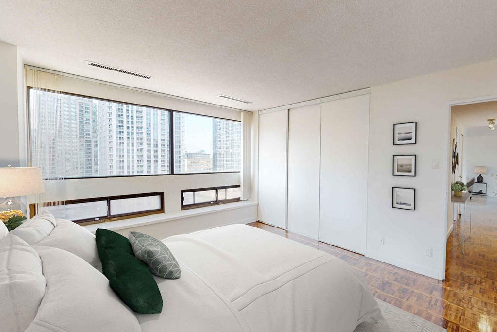 a bedroom with a large bed next to a window