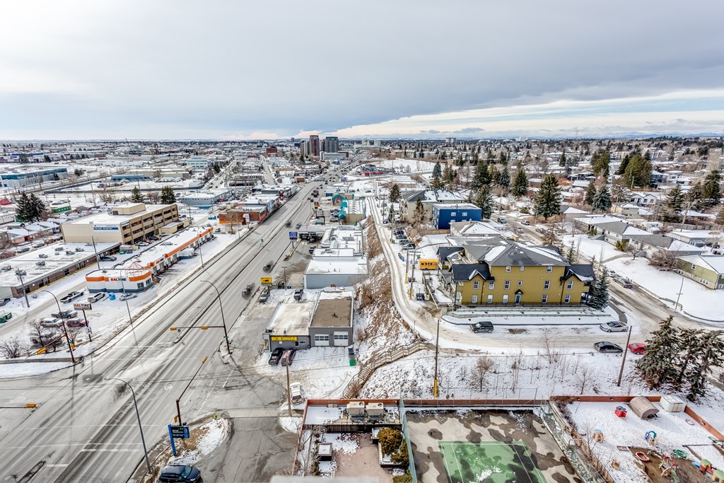 A view of a city with roads, buildings, and a snowy landscape.