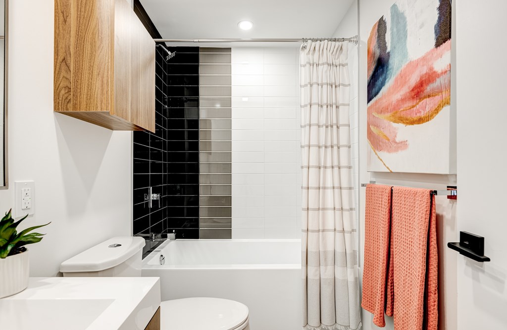 A bathroom with a white toilet, sink, and a shower curtain.