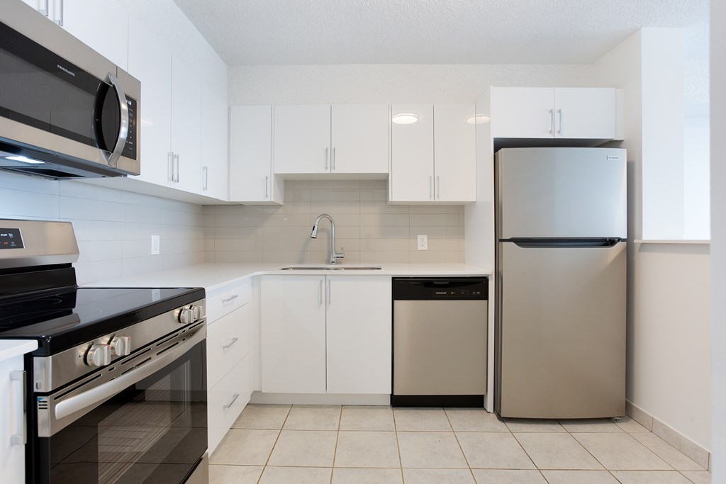 A kitchen with white cabinets and a black stove top oven.