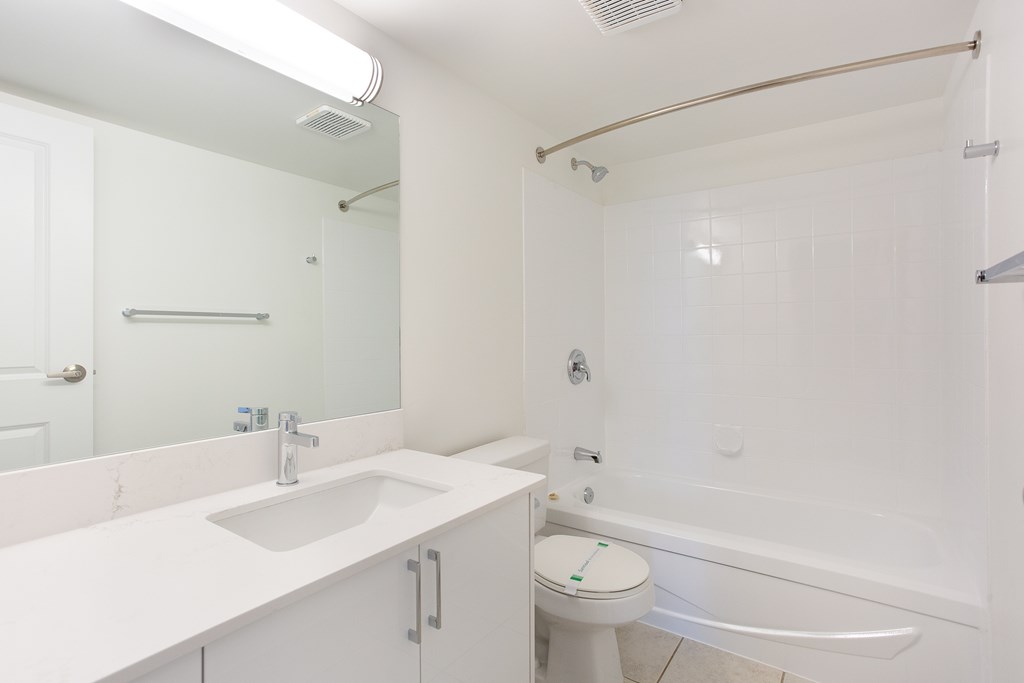 A white bathroom with a toilet, sink, and bathtub.
