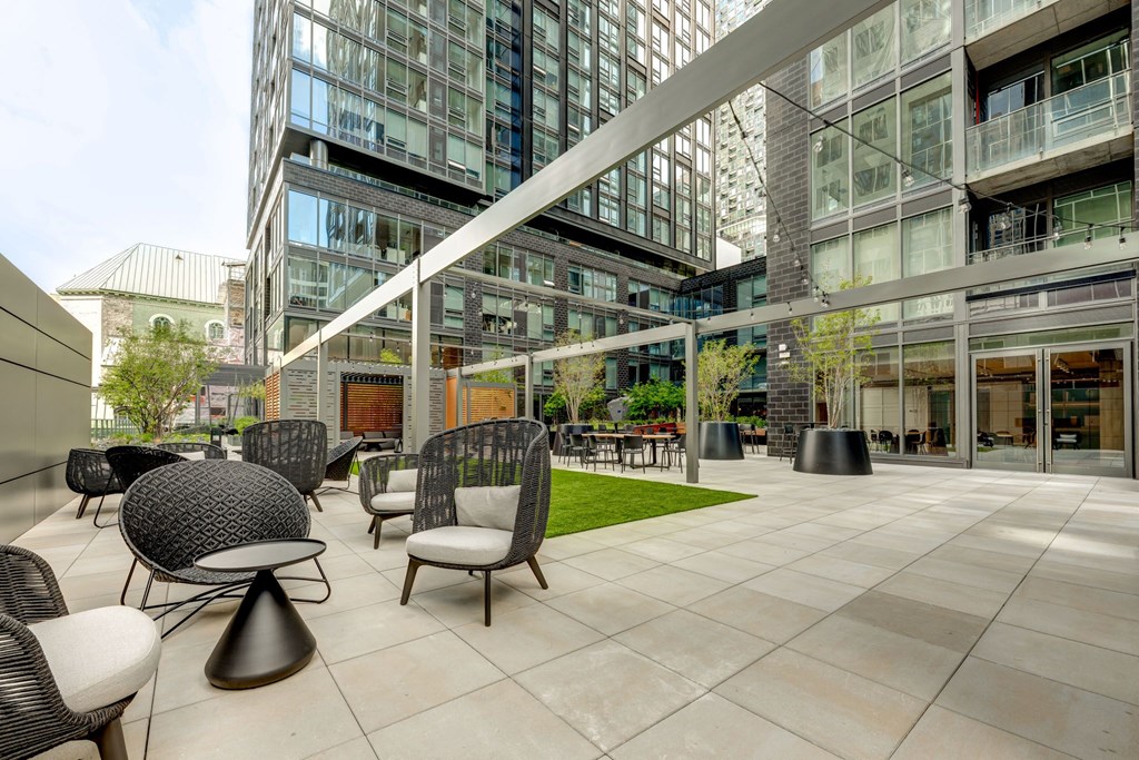 A modern outdoor seating area with black and white chairs and tables.