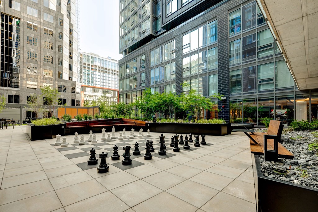 A giant chess board is set up on a patio.
