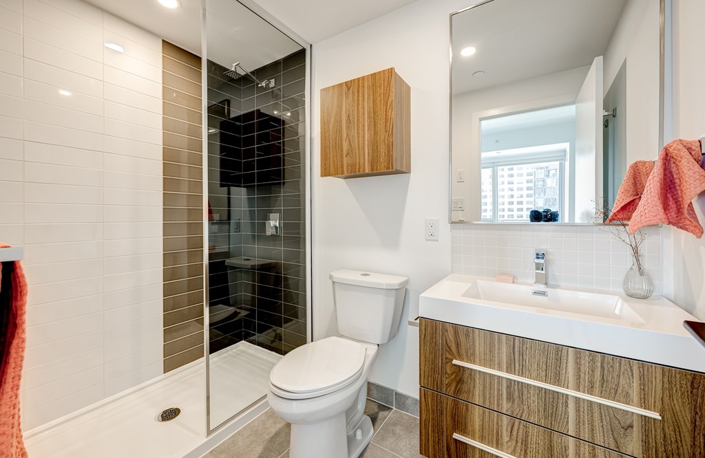 A bathroom with a toilet, sink, and shower.