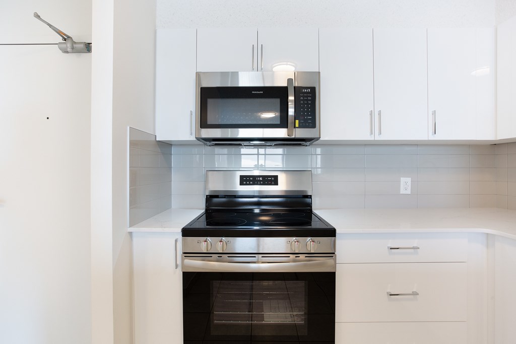 A modern kitchen with a black stove top oven and a microwave above it.