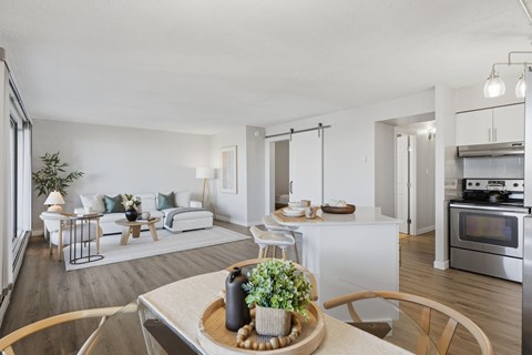 A modern living room with a dining table set in the middle.
