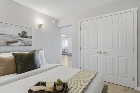 A bedroom with a large bed and a painting on the wall.