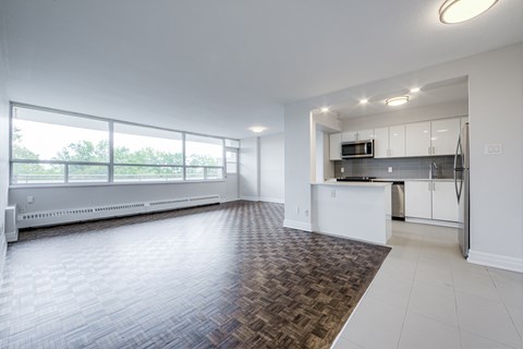 A spacious kitchen and living room with a large window.