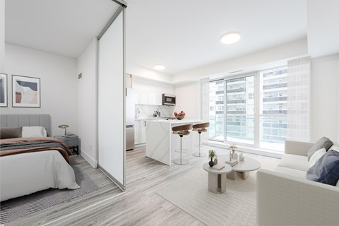 A modern bedroom with a large bed and a separate living area with a couch.