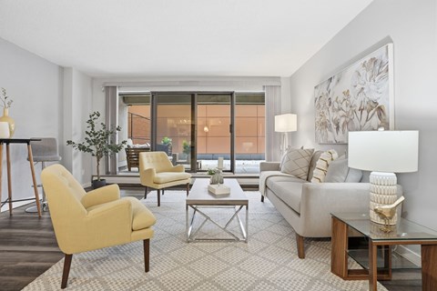 A living room with a yellow chair and a white couch.