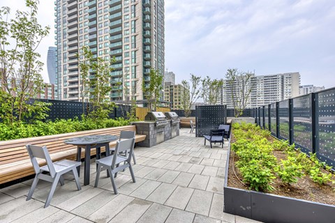 A patio with a table and chairs overlooking a cityscape.