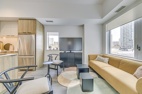 A modern living room with a yellow sofa and a television.