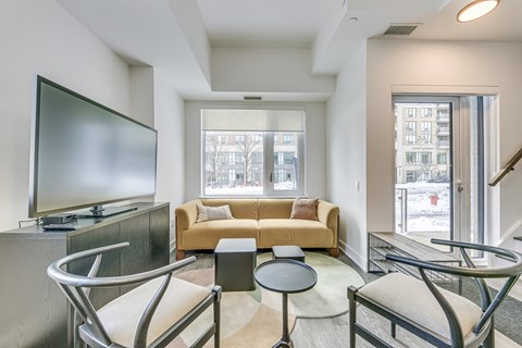 A living room with a yellow couch and a television.
