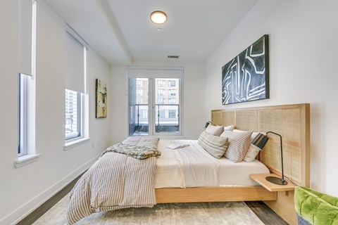 A bedroom with a large bed and a painting on the wall.