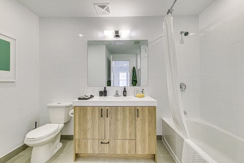 A white bathroom with a toilet, sink, and mirror.