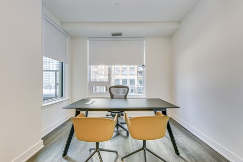 A conference room with a table and chairs.