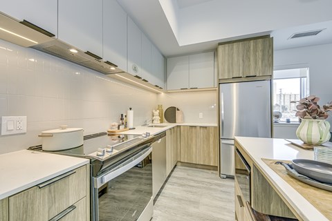 A modern kitchen with wooden cabinets and stainless steel appliances.